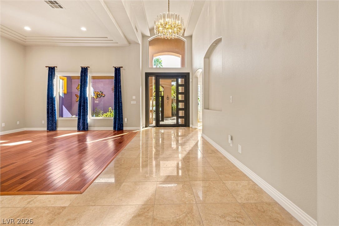 1517 Marbella Ridge Court, Las Vegas, NV 89117 Polished tile and warm hardwood flooring meet under soaring ceilings near the grand entrance foyer.