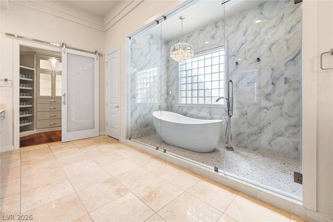 1517 Marbella Ridge Court, Las Vegas, NV 89117 A glass-enclosed shower wet room showcases a freestanding tub beneath high ceilings and tile flooring.