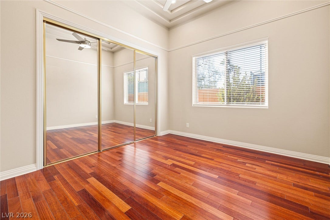 1517 Marbella Ridge Court, Las Vegas, NV 89117 Rich hardwood floors and soaring tray ceilings define this light-filled room with mirrored closet doors.
