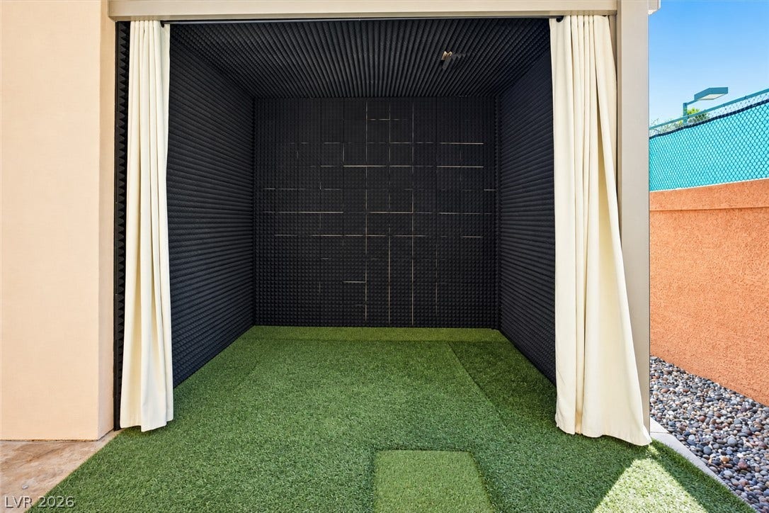 1517 Marbella Ridge Court, Las Vegas, NV 89117 An outdoor golf bay featuring protective wall padding and synthetic turf underfoot.