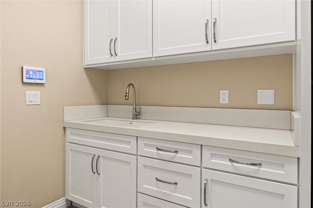 1517 Marbella Ridge Court, Las Vegas, NV 89117 Crisp white cabinetry paired with durable solid surface countertops offers abundant storage and functionality.