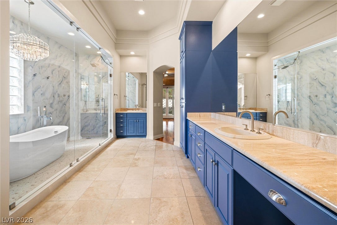 1517 Marbella Ridge Court, Las Vegas, NV 89117 Gleaming tile floors and custom cabinetry anchor a spacious bath with a glass-enclosed shower.