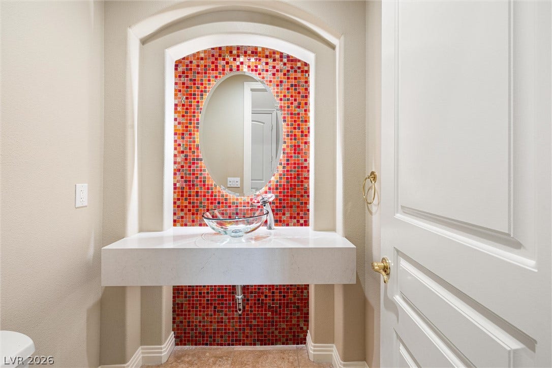1517 Marbella Ridge Court, Las Vegas, NV 89117 Vibrant mosaic tile creates a bold accent behind a modern floating vanity.