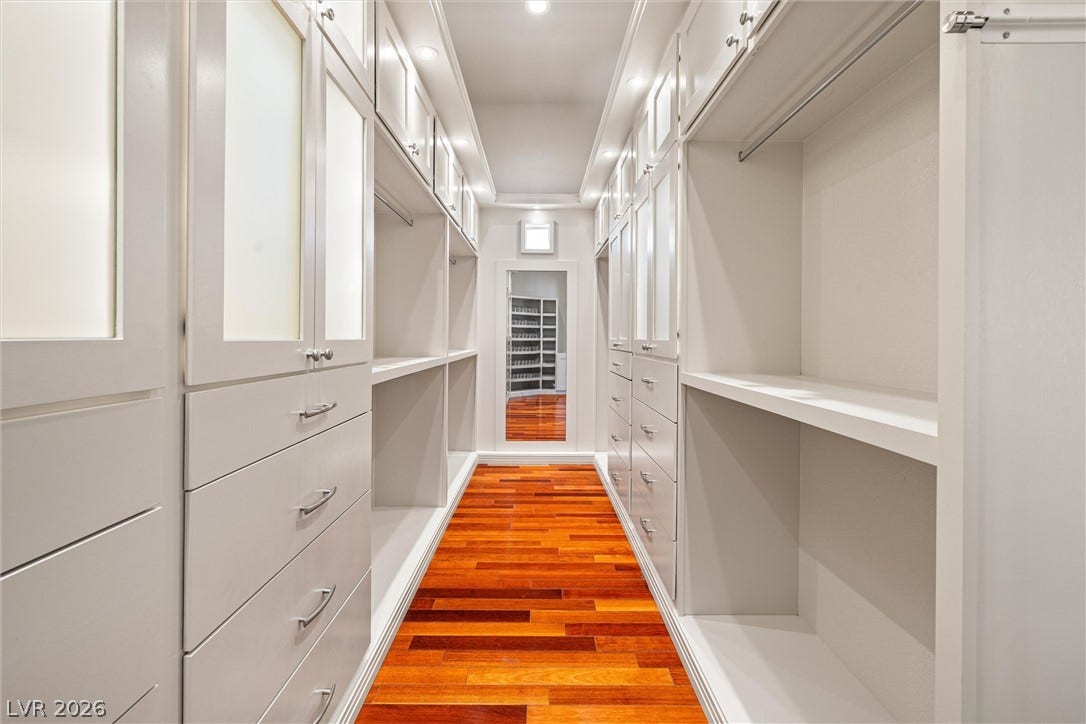 1517 Marbella Ridge Court, Las Vegas, NV 89117 Rich hardwood flooring anchors this customized dressing area lined with extensive built-in cabinetry.