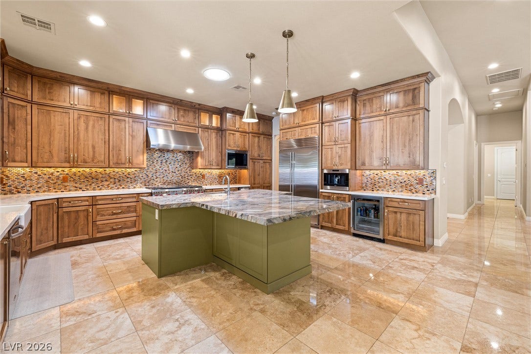 1517 Marbella Ridge Court, Las Vegas, NV 89117 Gleaming tile floors anchor this gourmet kitchen featuring rich wood cabinetry and a central island.