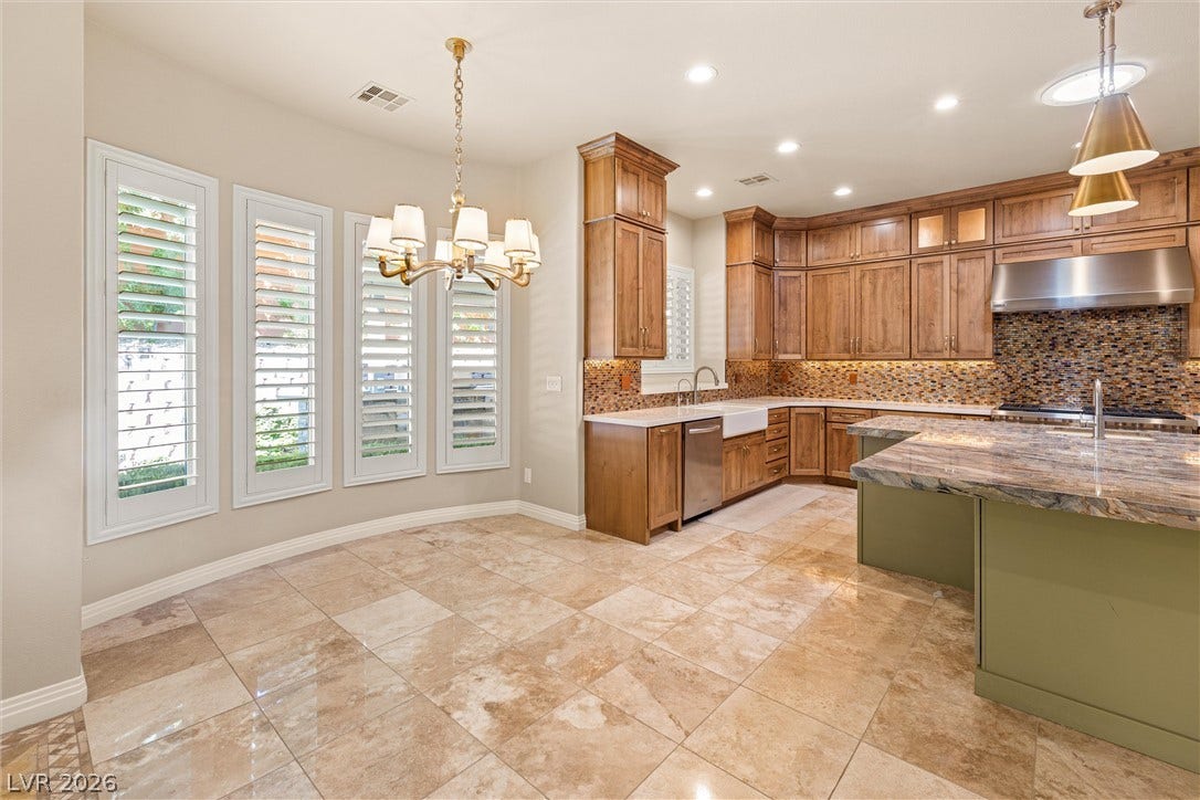 1517 Marbella Ridge Court, Las Vegas, NV 89117 Polished tile flooring and warm wood cabinetry define this open culinary space.