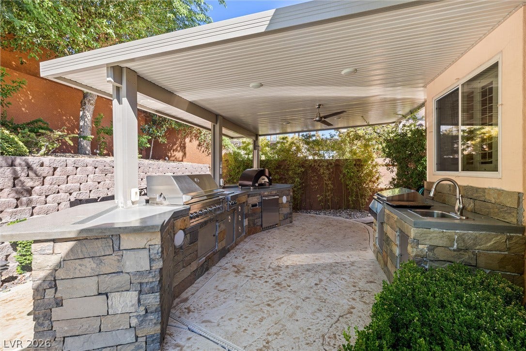 1517 Marbella Ridge Court, Las Vegas, NV 89117 An expansive covered outdoor kitchen features stone accents and premium built-in grilling equipment.