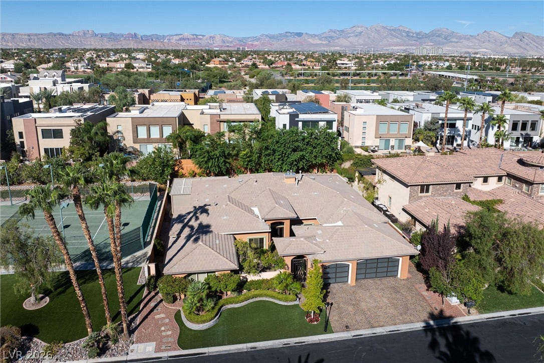1517 Marbella Ridge Court, Las Vegas, NV 89117 An aerial perspective captures the beautiful tile roof and brick driveway against a mountain backdrop.
