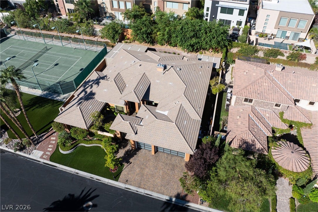 1517 Marbella Ridge Court, Las Vegas, NV 89117 An aerial view showcases a multi-gabled tile roof beside an adjacent private tennis court.