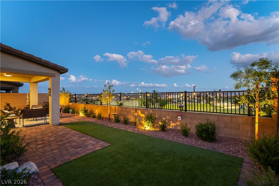 10583 Valletta Avenue, Las Vegas, NV 89166 Neat pavers and lush synthetic turf frame this landscaped yard under open blue skies.