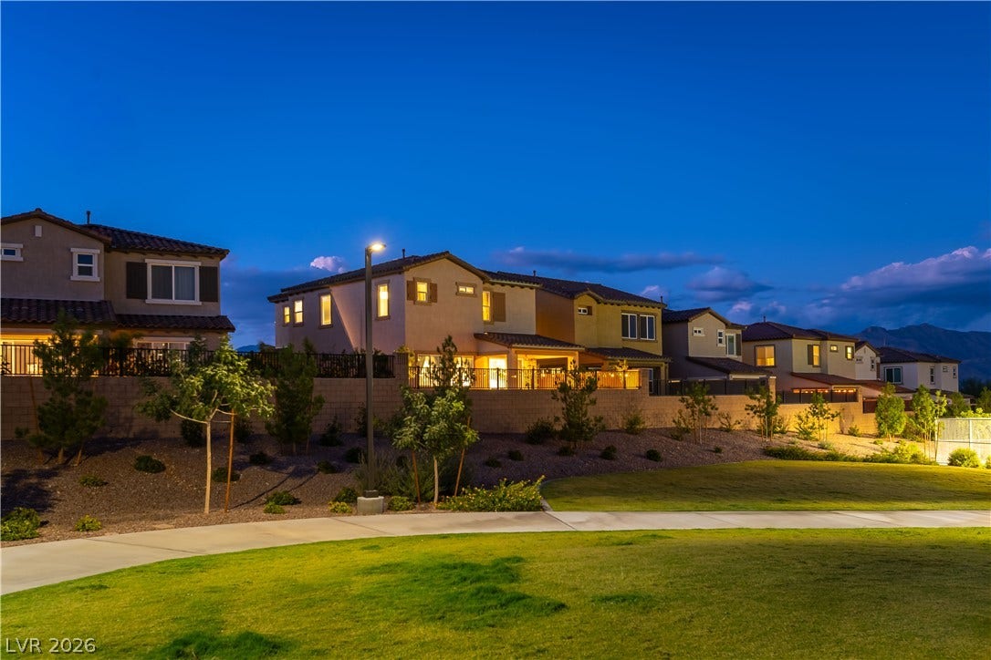 10583 Valletta Avenue, Las Vegas, NV 89166 Lush green space borders these modern residences nestled against a serene mountain backdrop.