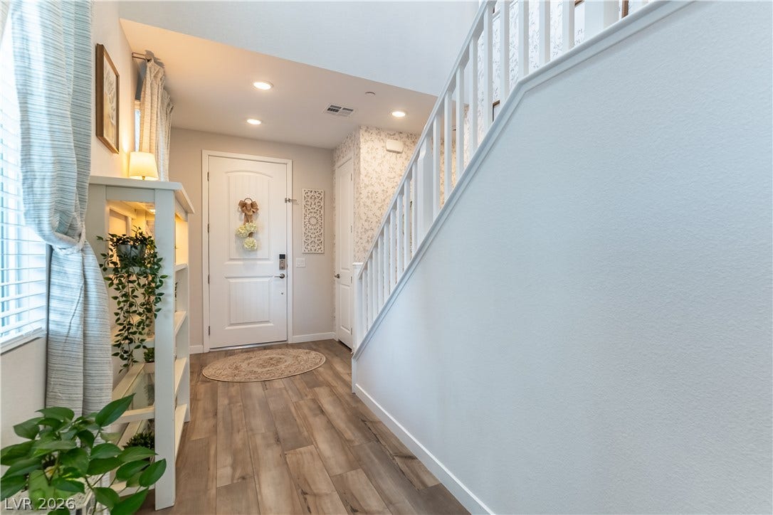 10583 Valletta Avenue, Las Vegas, NV 89166 An inviting entrance foyer reveals rich wood-look flooring and a clean balustrade flanking the staircase.