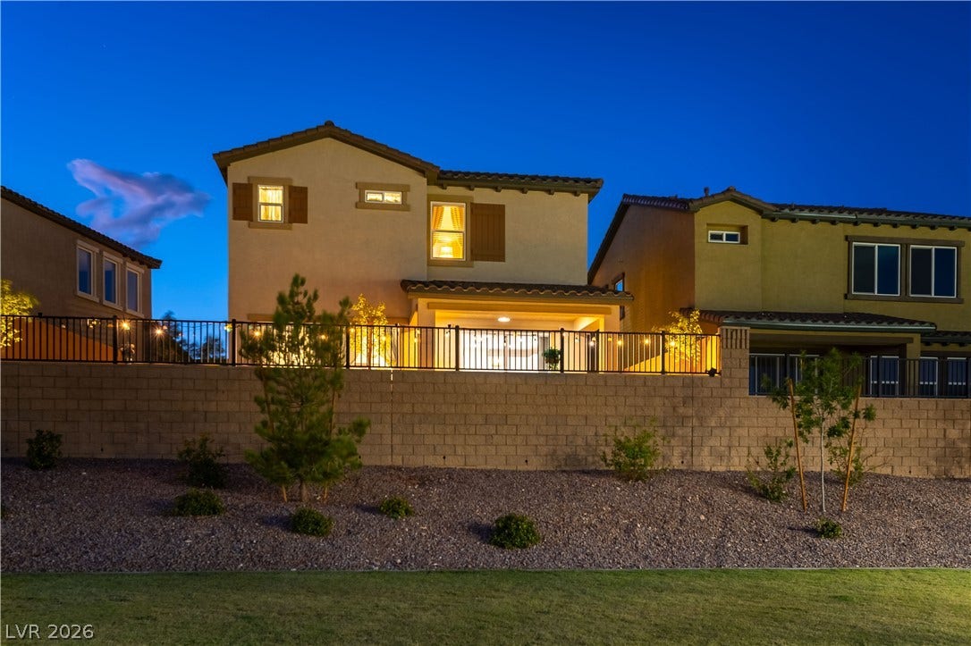 10583 Valletta Avenue, Las Vegas, NV 89166 A sturdy retaining wall and black metal fencing frame the rear facade of this multi-level home.