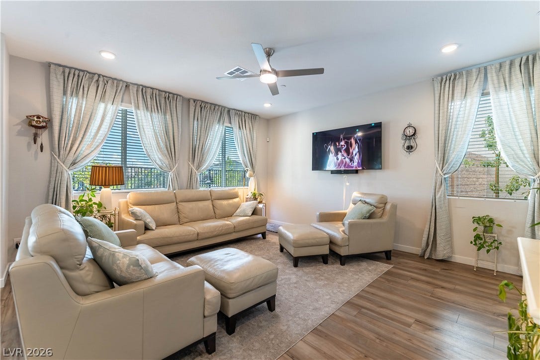 10583 Valletta Avenue, Las Vegas, NV 89166 Rich wood-inspired floors and extensive windows frame this comfortable living space.