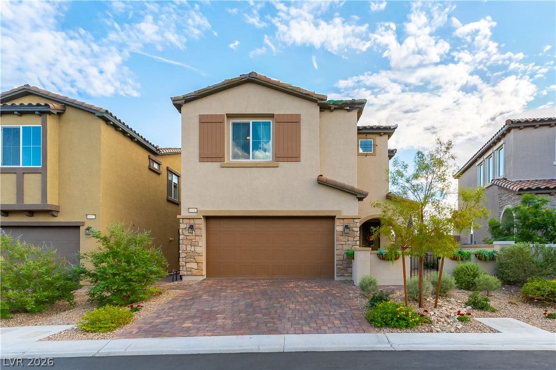 10583 Valletta Avenue, Las Vegas, NV 89166 Stucco cladding, stone accents, and a paved driveway elevate this multi-level home's exterior appeal.
