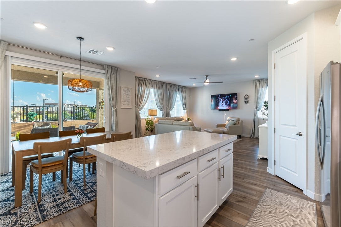 10583 Valletta Avenue, Las Vegas, NV 89166 An open floorplan seamlessly connects the stone counters of this kitchen with the dining area.