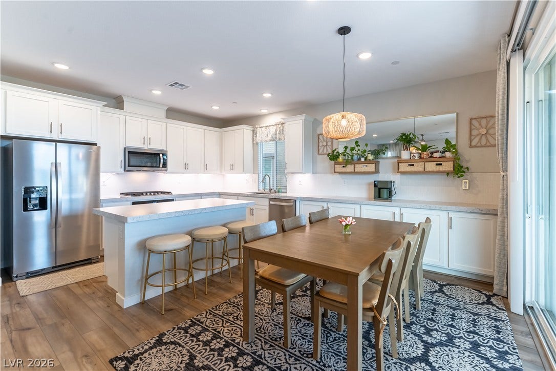 10583 Valletta Avenue, Las Vegas, NV 89166 Recessed lighting illuminates this seamless transition between a modern kitchen and an adjoining dining space.