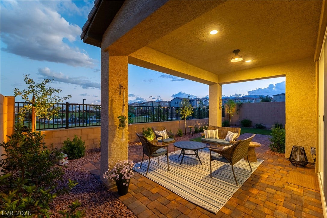 10583 Valletta Avenue, Las Vegas, NV 89166 An inviting covered patio features warm recessed lighting and overlooks a paved backyard.
