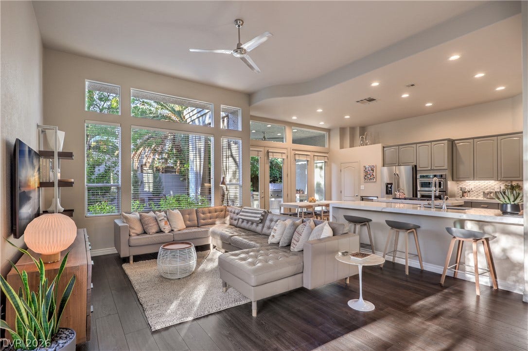 Gleaming hardwood floors and towering windows highlight this open-concept main living space.