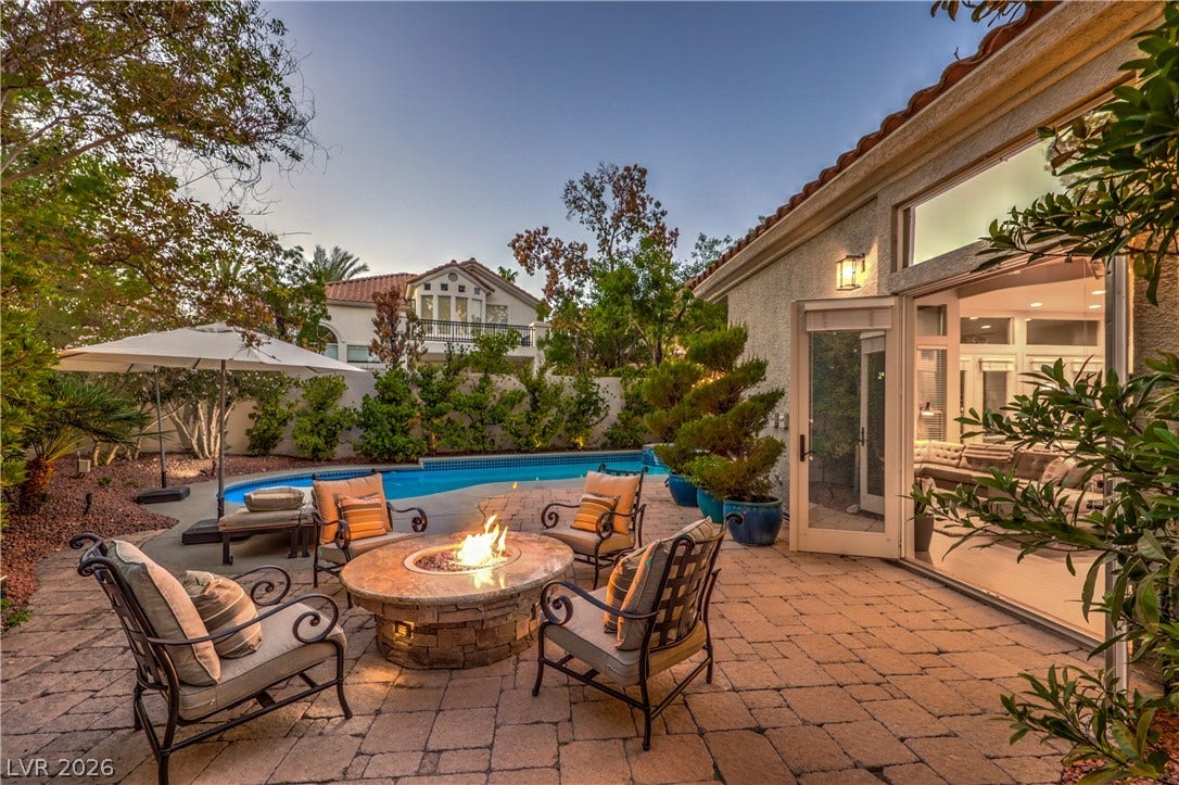 An inviting stone patio opens directly to the private pool and manicured garden.