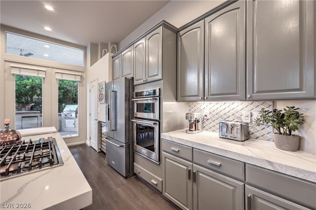 Premium quartz countertops and professional stainless steel appliances anchor this modern culinary space.