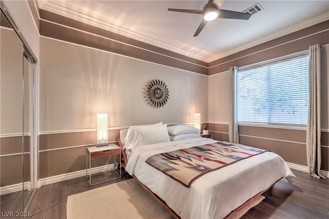 Elegant crown molding complements warm wood-style flooring in this restful sanctuary.