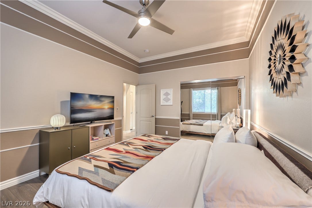 Elegant crown molding and classic wainscoting highlight this refined modern bedroom.
