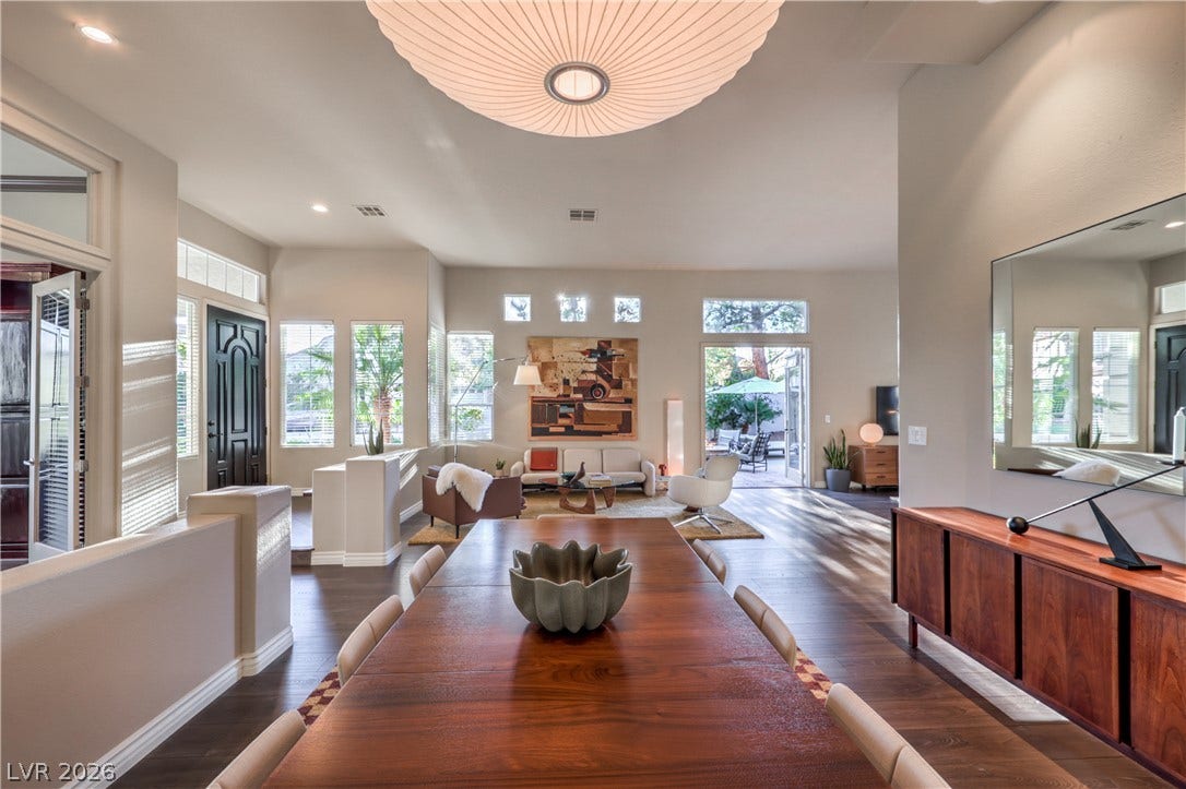 An open dining area flows seamlessly into the main living space over rich hardwood floors.