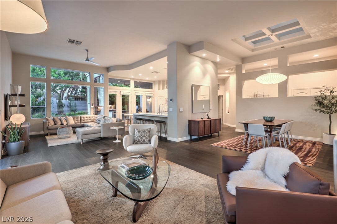 Rich hardwood flooring anchors the fluid, light-filled layout of this modern open living space.