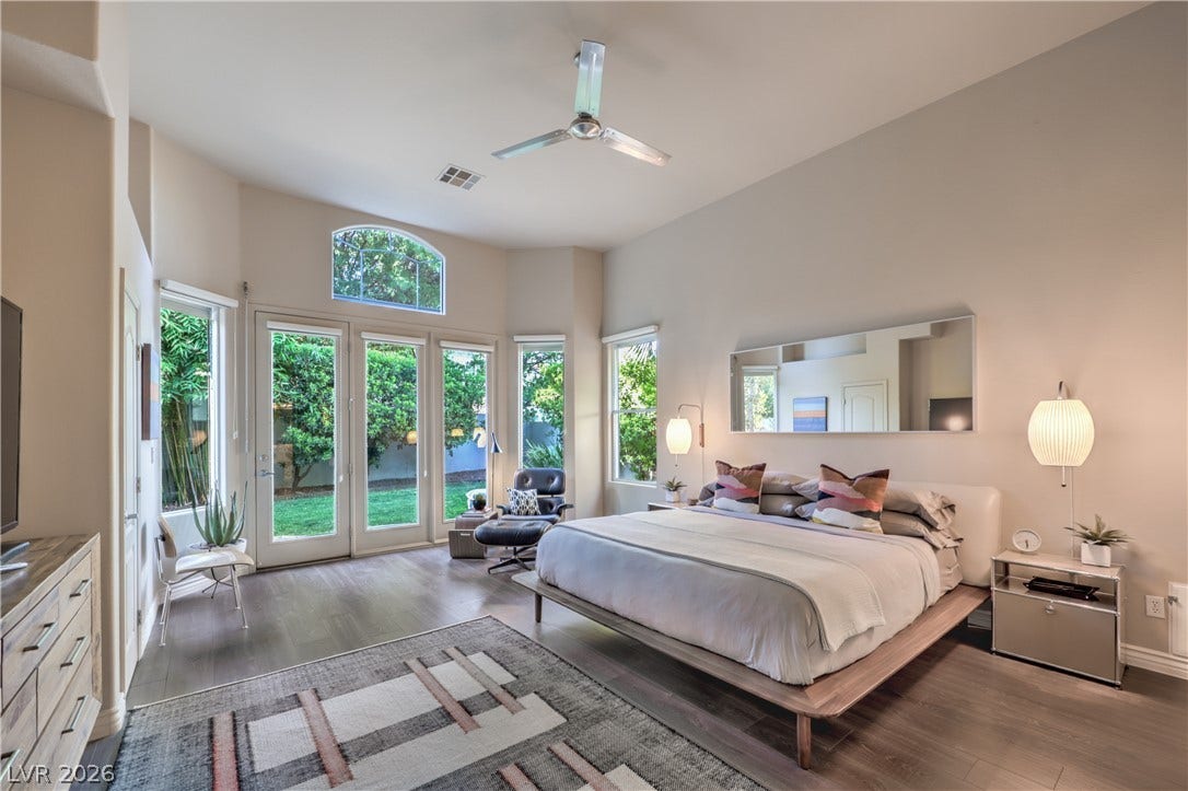 High ceilings and tall glass doors create an airy atmosphere in this bedroom.