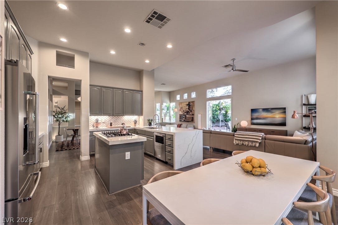 Hardwood floors and recessed lighting anchor this open-concept layout connecting the kitchen and living areas.