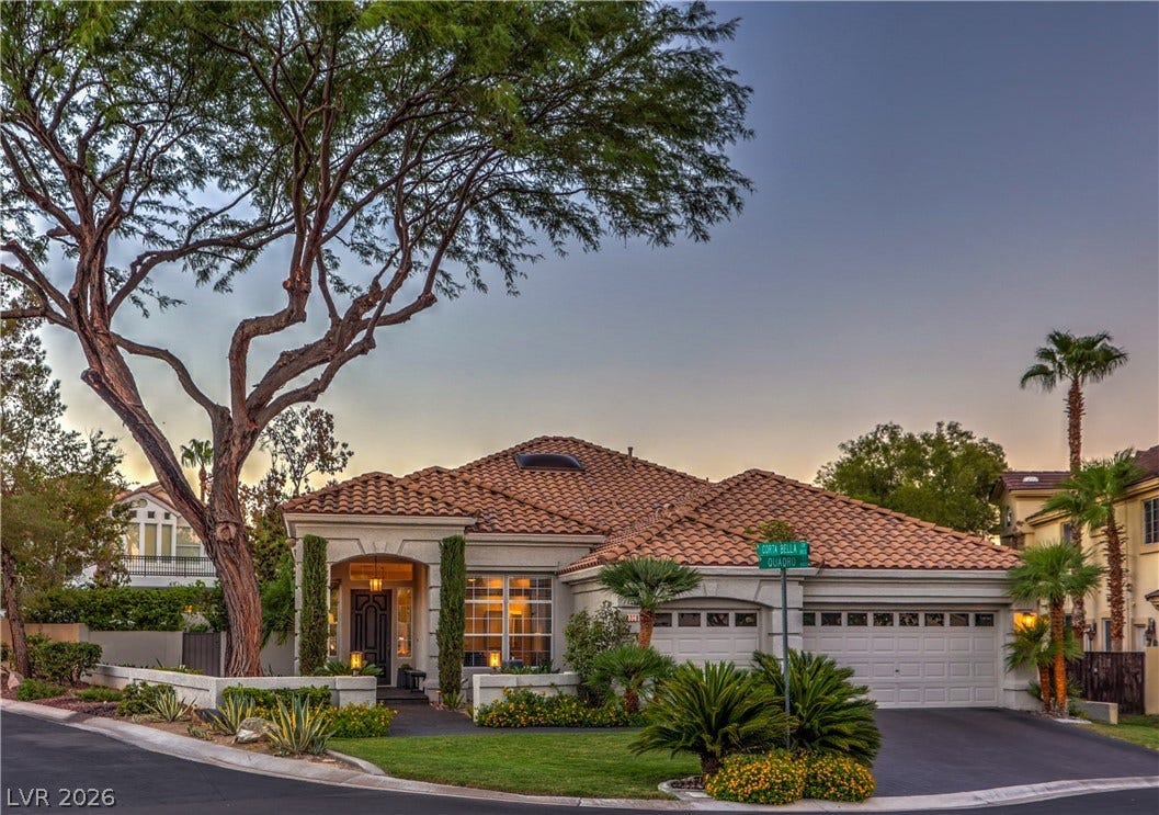 A classic tiled roof and manicured landscaping frame this elegant single-story home on a corner lot.