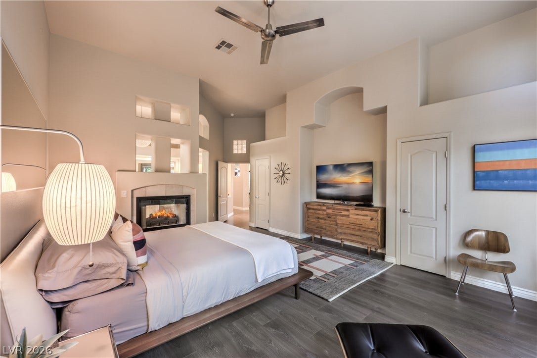 A double-sided fireplace and soaring ceilings bring architectural depth to this spacious suite.