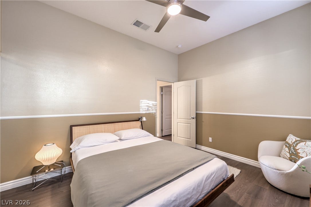 Gleaming hardwood floors and classic chair rail molding define this serene bedroom space.