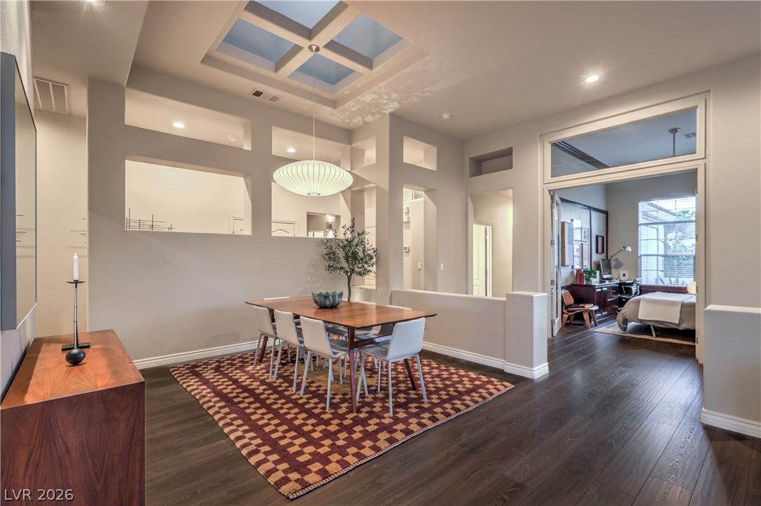 Rich hardwood floors and a geometric skylight structure create an intriguing architectural atmosphere.