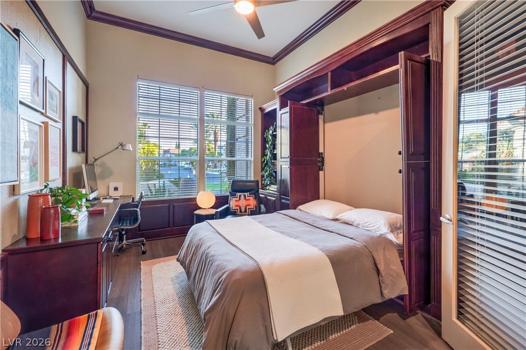 Gleaming hardwood floors and towering windows frame a versatile space complete with custom built-in cabinetry.