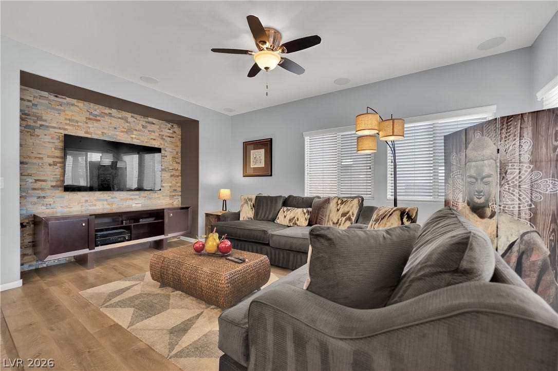 1421 Lamance Court, North Las Vegas, NV 89031 Rich wood-look flooring and a textured stone accent wall anchor this comfortable gathering space.