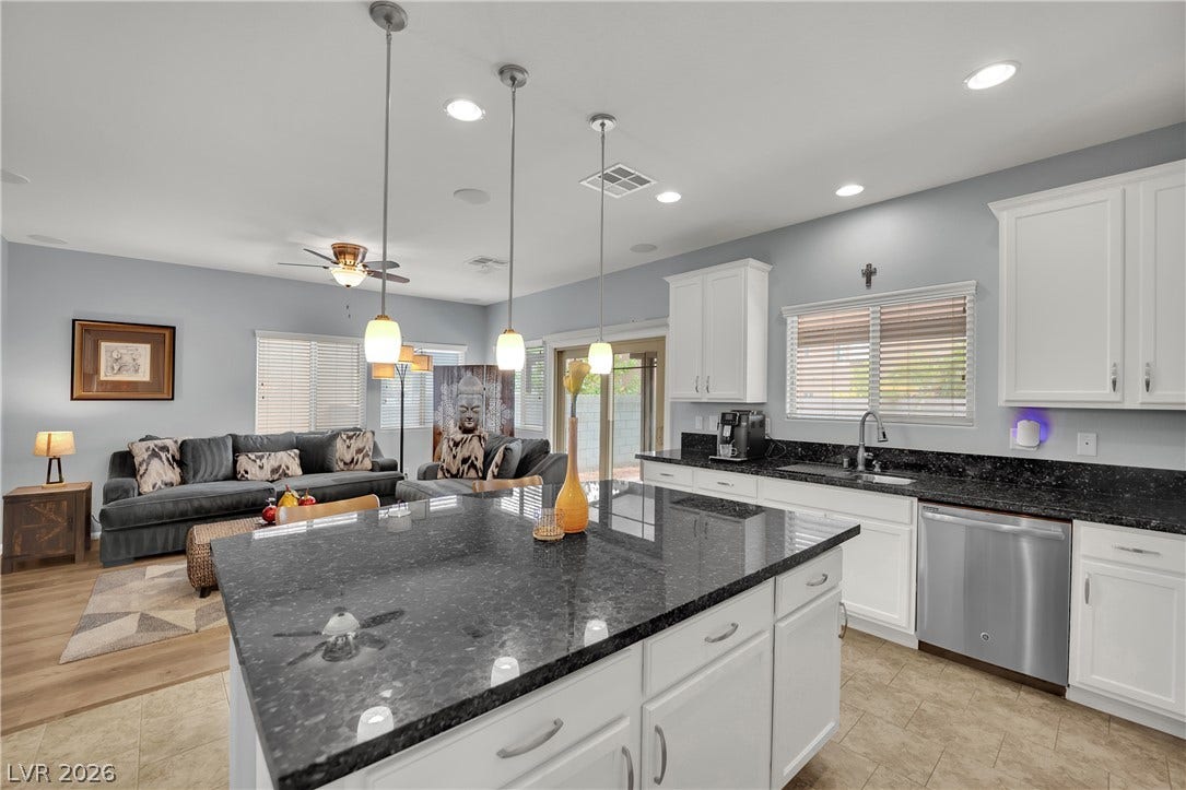1421 Lamance Court, North Las Vegas, NV 89031 Gleaming dark granite countertops contrast beautifully with classic white cabinetry in an airy open layout.