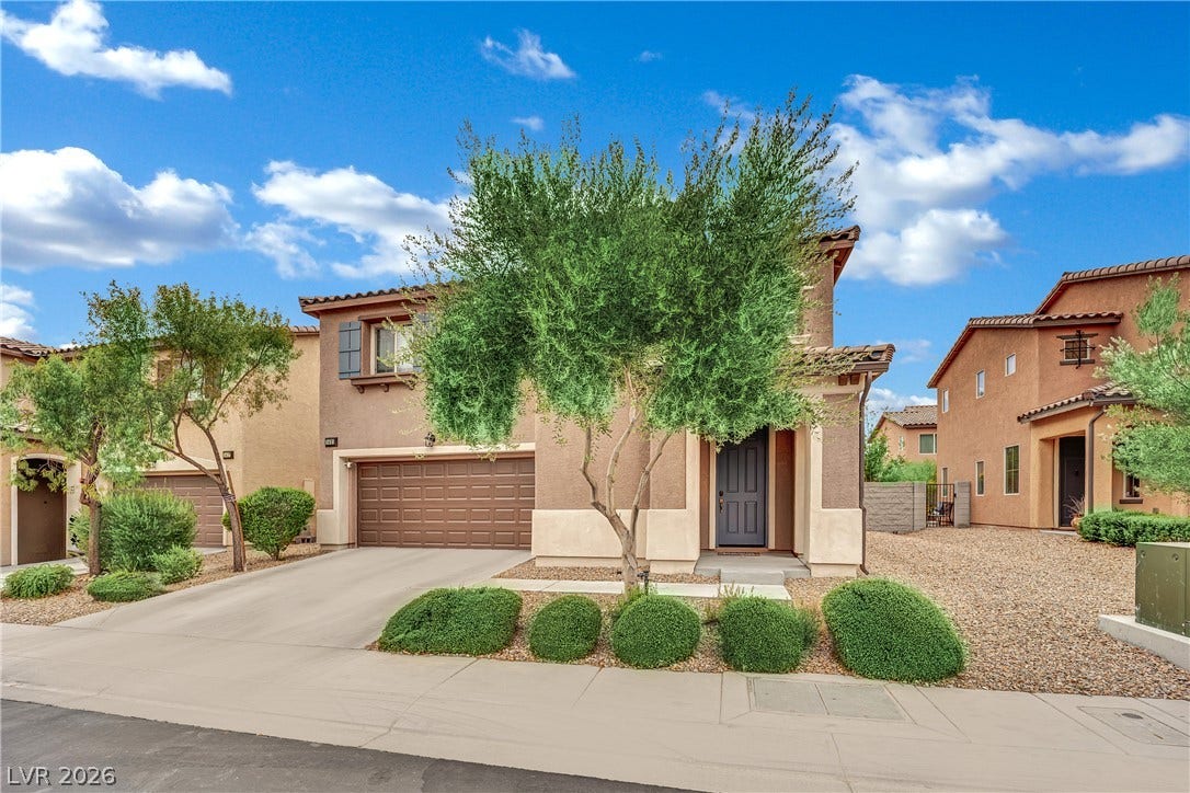 1421 Lamance Court, North Las Vegas, NV 89031 A paved driveway leads to a multi-level home with stucco siding and tile roofing.