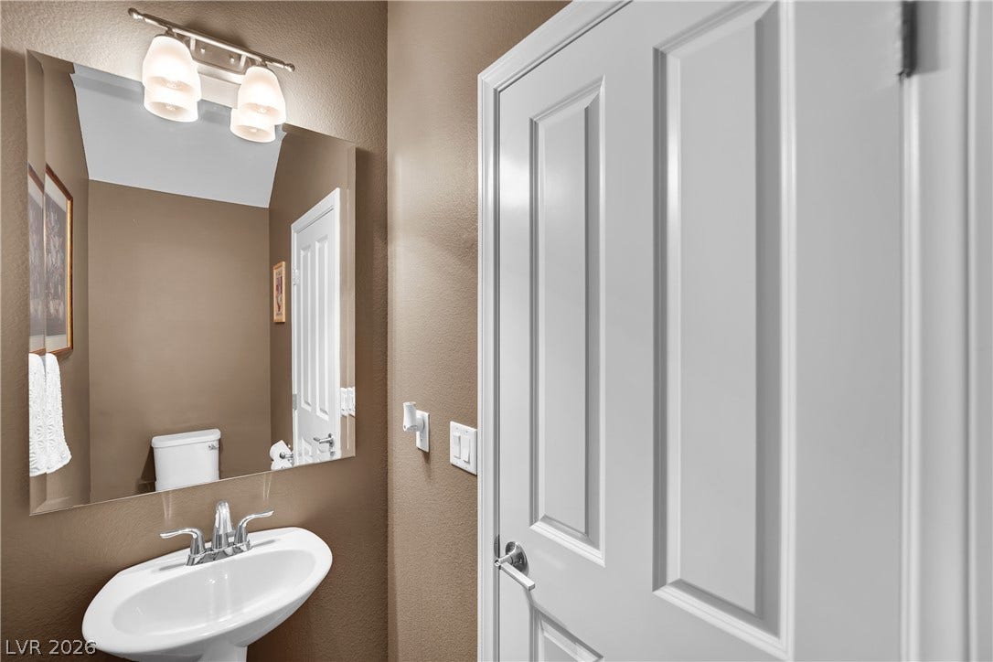 1421 Lamance Court, North Las Vegas, NV 89031 A classic pedestal sink paired with a large wall mirror updates this powder room.