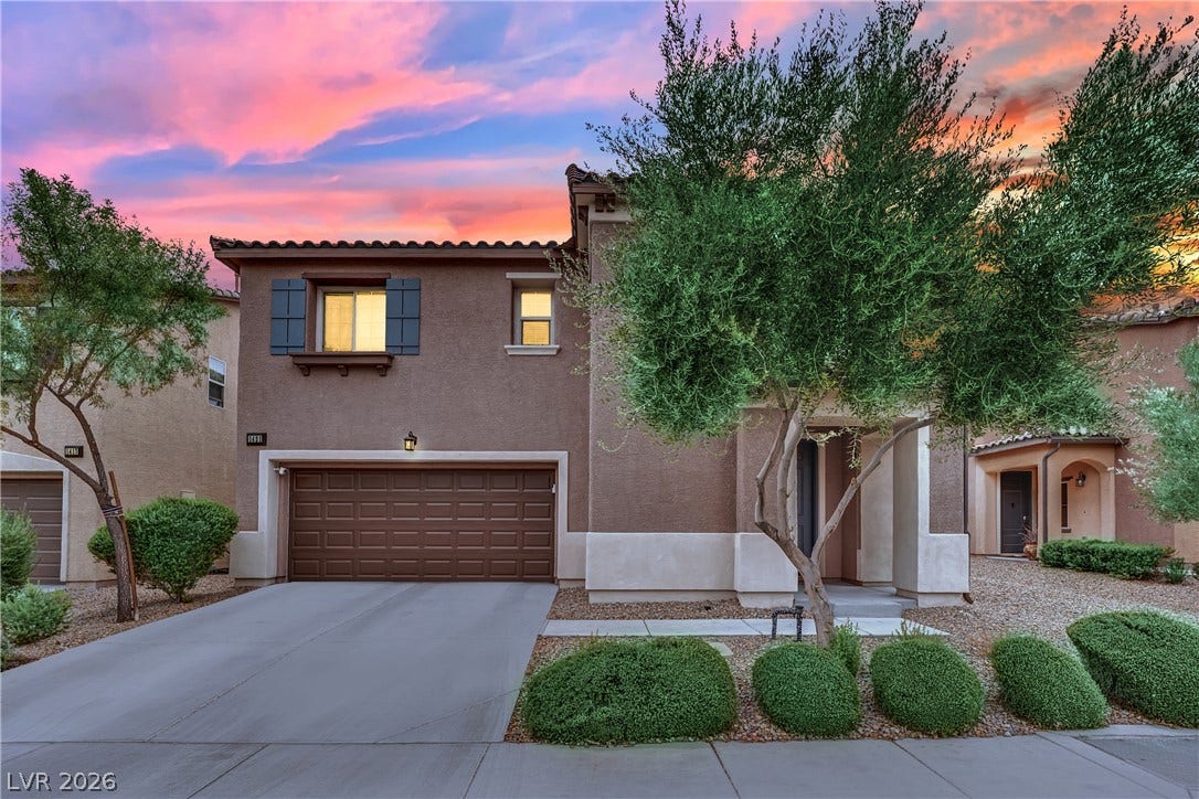 1421 Lamance Court, North Las Vegas, NV 89031 An inviting exterior features a paved driveway leading to a two-car garage under dramatic evening skies.