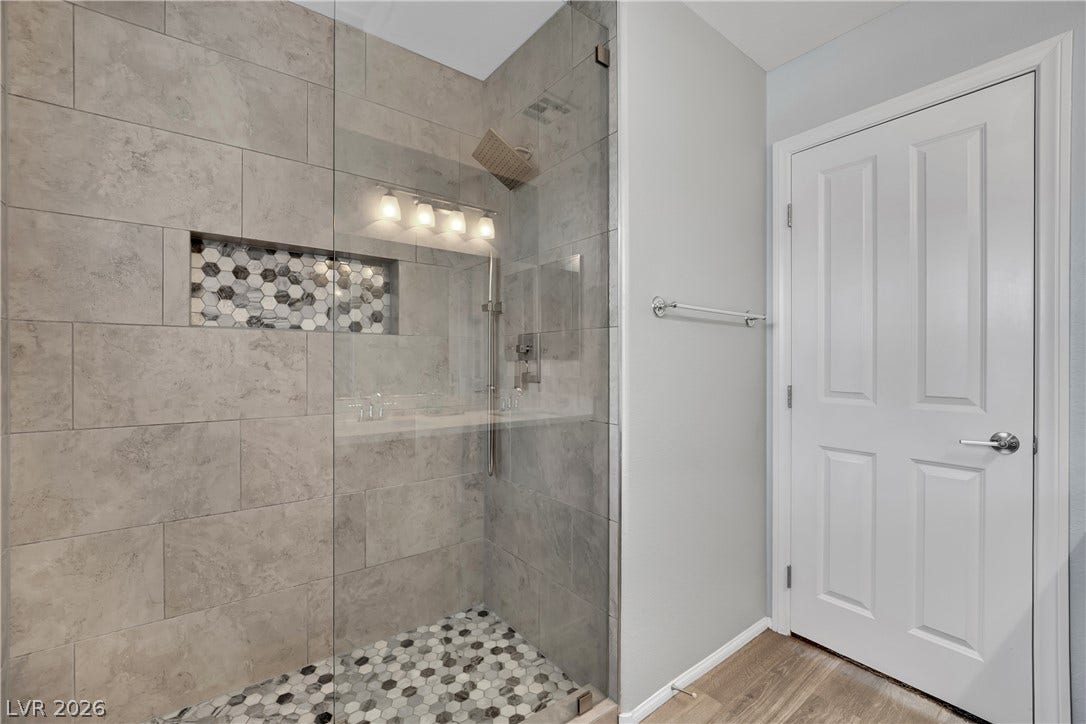 1421 Lamance Court, North Las Vegas, NV 89031 An elegant walk-in shower features large-format wall tile and a custom hexagon-tiled niche.
