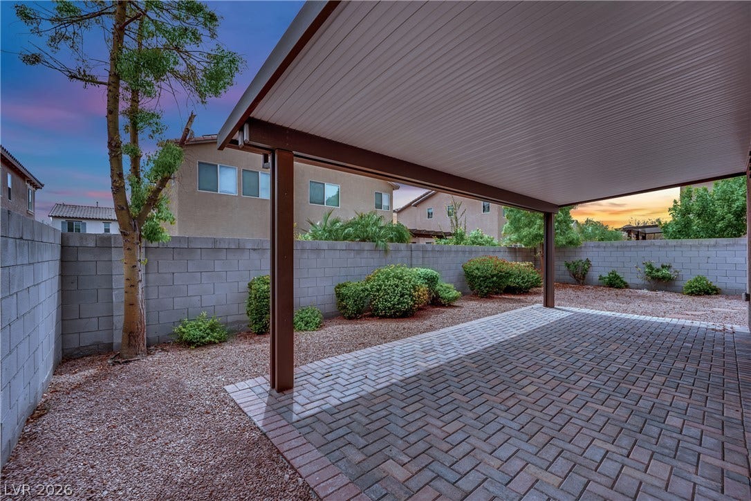 1421 Lamance Court, North Las Vegas, NV 89031 An inviting covered patio features neat brick pavers alongside a low-maintenance gravel yard.