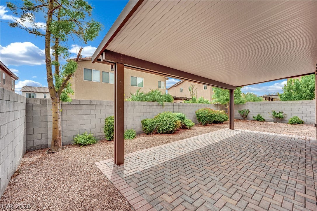 1421 Lamance Court, North Las Vegas, NV 89031 A sheltered brick paver patio extends into a low-maintenance backyard enclosed by block fencing.