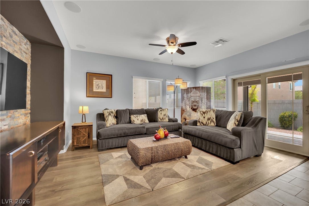 1421 Lamance Court, North Las Vegas, NV 89031 An inviting stone fireplace wall complements the warm wood flooring in this open living area.