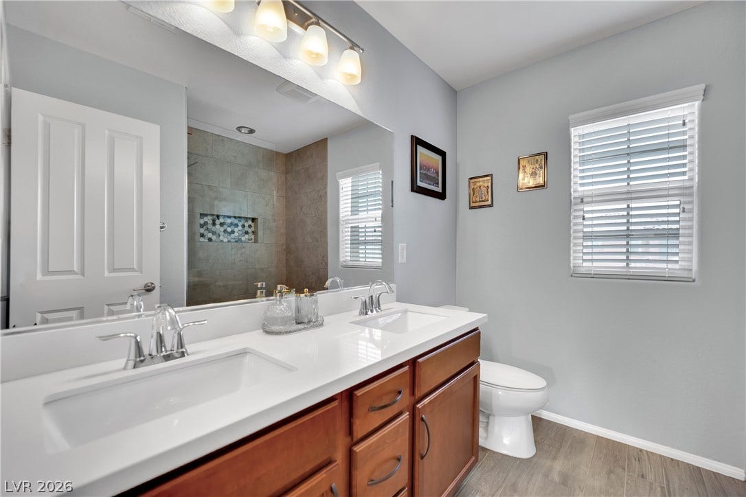 1421 Lamance Court, North Las Vegas, NV 89031 Double vanities and wood-look flooring enhance this updated bath with a tiled shower.