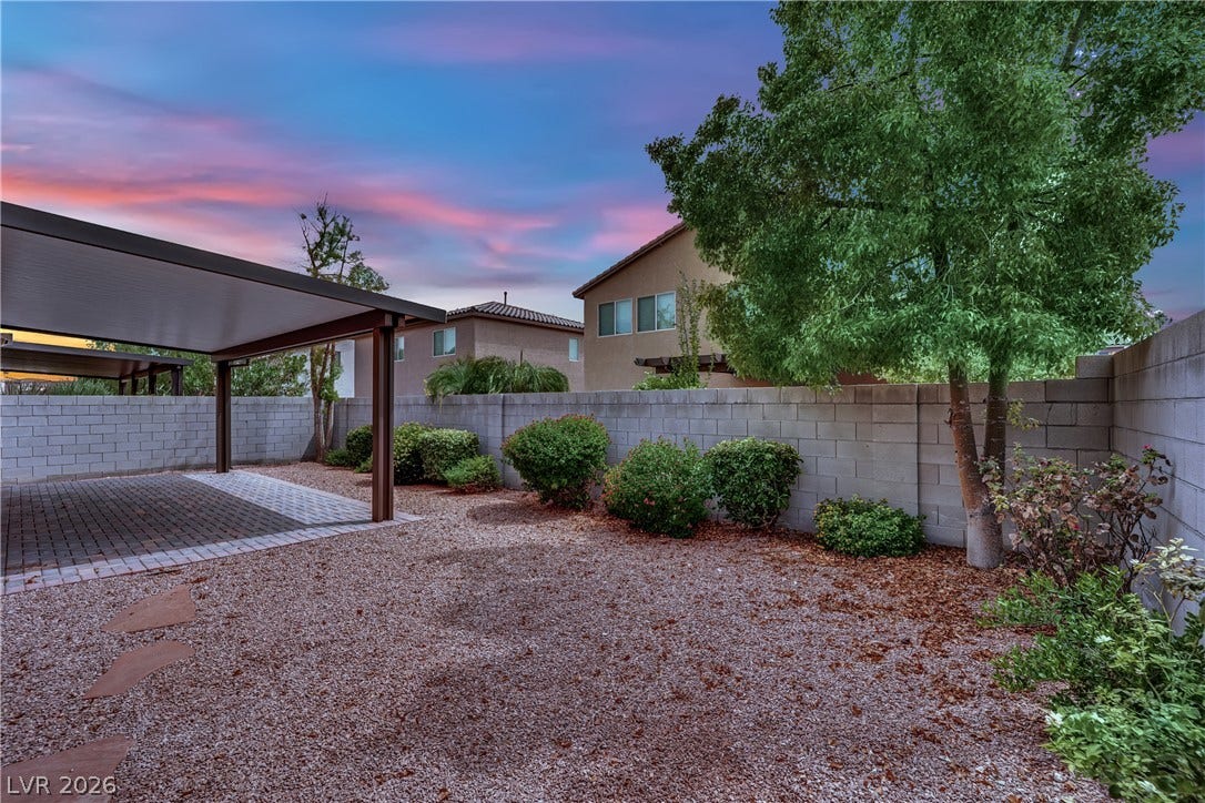 1421 Lamance Court, North Las Vegas, NV 89031 An enclosed backyard features gravel landscaping and a covered patio set against block fencing.