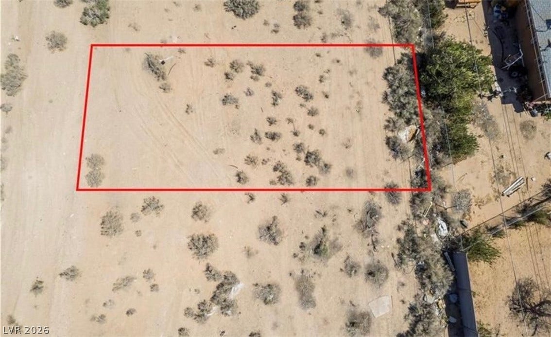 An aerial perspective outlines the level desert terrain of this expansive undeveloped lot.