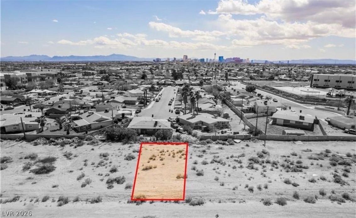 Distant city skyline views frame this vacant desert parcel nestled near an established neighborhood.