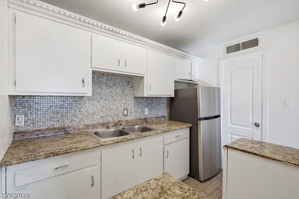 3726 Hazelwood Street, #14, Las Vegas, NV 89119 Timeless granite countertops and crisp white cabinetry define this highly functional culinary space.
